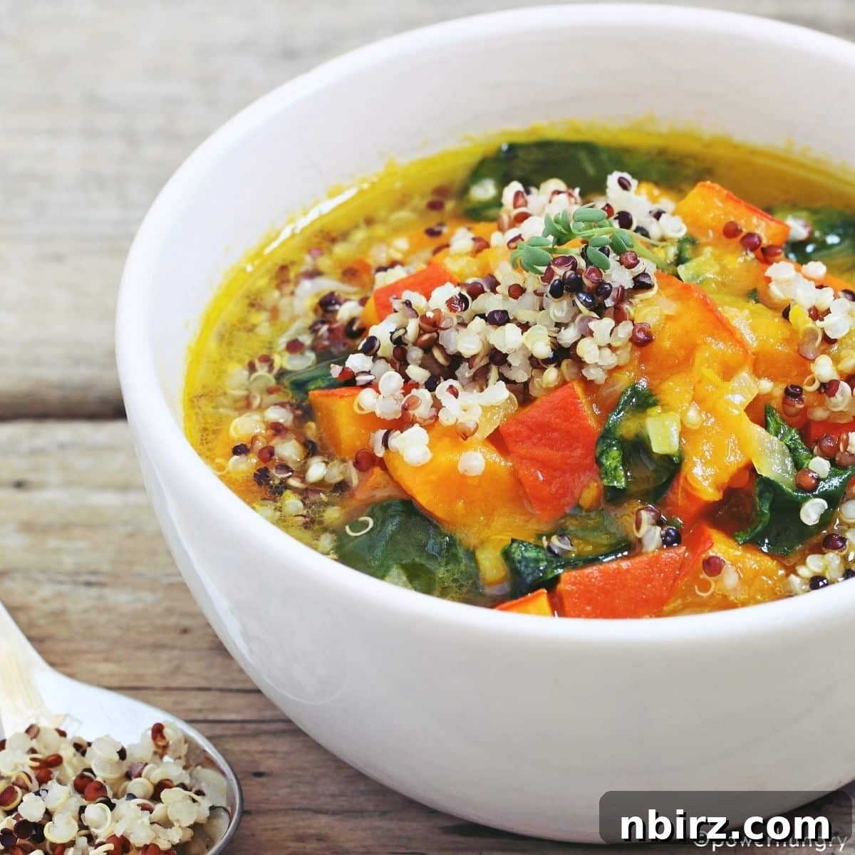 Wholesome Vegan Gluten Free Oil Free Quinoa Minestrone 4 A beautifully presented bowl of quinoa minestrone, served on a rustic wooden surface, ready to be enjoyed.