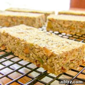 Homemade vegan savory power bars neatly arranged on a black metal cooling rack.
