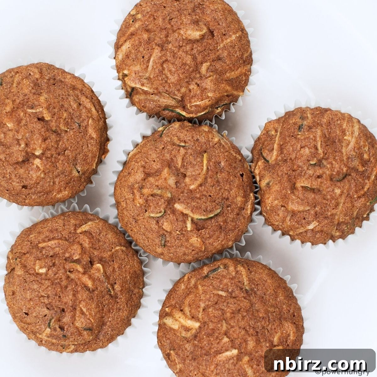 Grain Free Oil Free Vegan Almond Flour Zucchini Muffins 5 An inviting overhead shot of freshly baked zucchini almond flour muffins cooling on a wire rack, ready to be enjoyed.