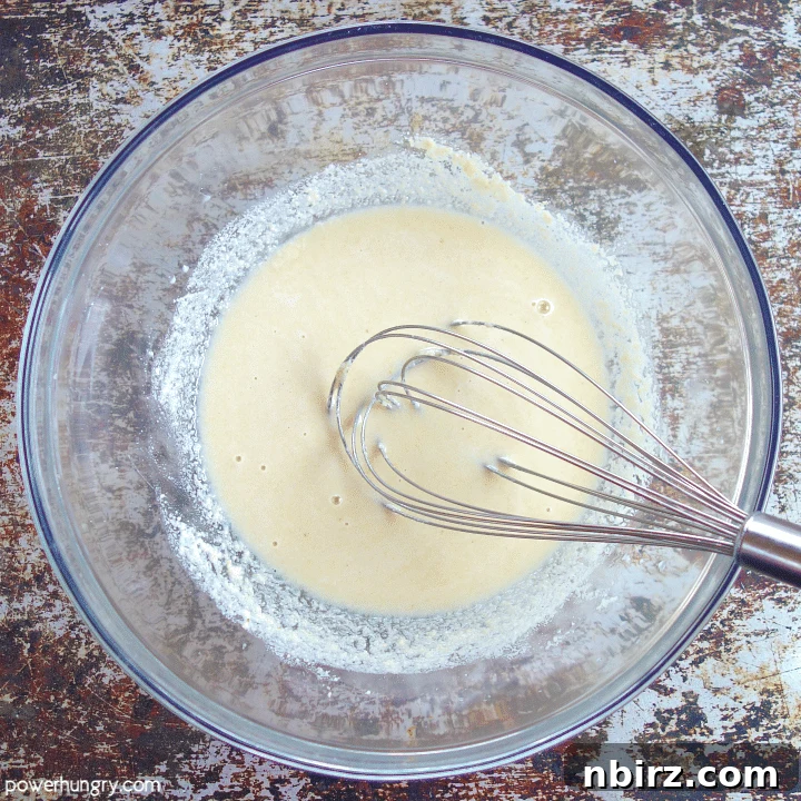 Glass bowl containing a smooth, creamy almond flour batter, ready for coating vegetables.