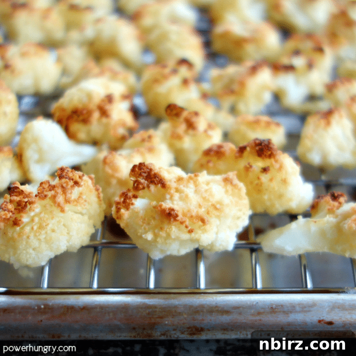 Roasted almond flour cauliflower popcorn spread evenly on a baking sheet, golden and crispy from the oven.