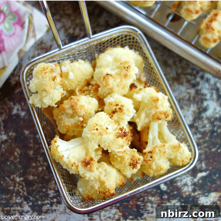 Overhead shot of a small basket of perfectly roasted almond flour cauliflower popcorn, showing off its inviting texture.