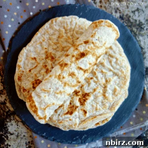 Rolled coconut flour tortilla on a stack of more tortillas
