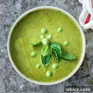Overhead shot of bright green soup made with split peas and frozen green peas in a white bowl.