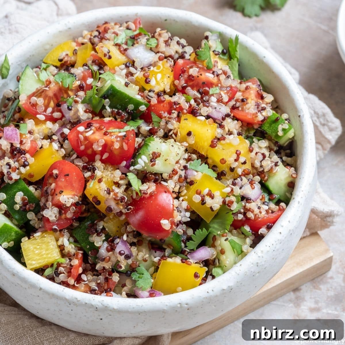 Vibrant Oil-Free Quinoa Bowl 4 A large white salad bowl filled with the colorful and healthy oil-free quinoa salad, featuring a perfect mix of grains and vegetables.