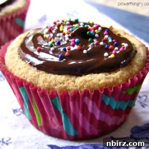 Vegan coconut flour cupcake topped with luscious chocolate frosting and colorful sprinkles, ready to be enjoyed.