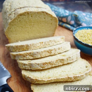 A loaf of millet sandwich bread, sliced, on a cutting board