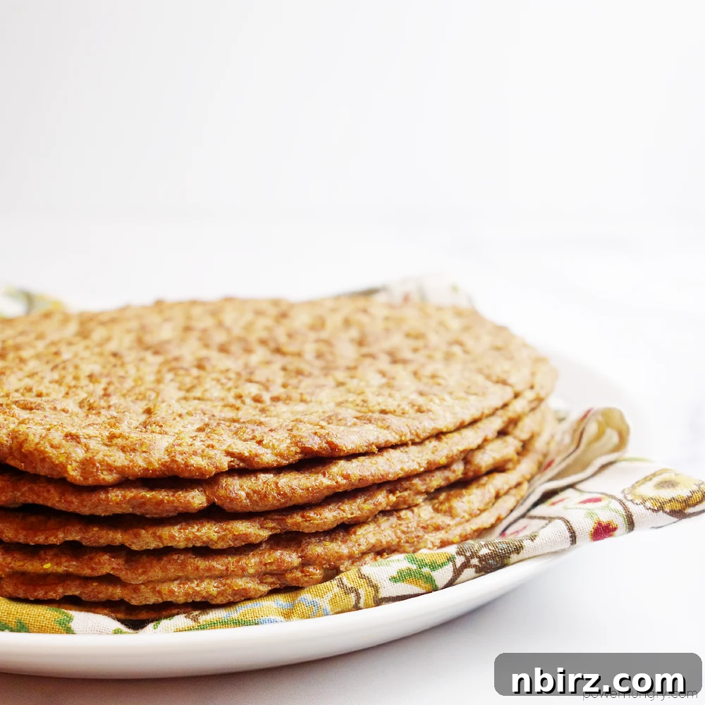 Effortless Keto Flaxseed Wraps 3 Close-up of a 1-ingredient flax tortilla placed on a white plate with a napkin, highlighting its texture and flexibility.