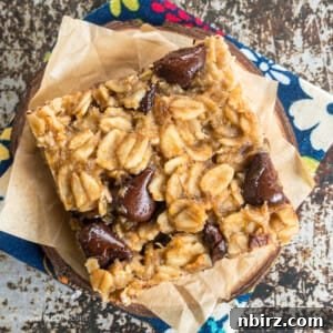 Effortless 4-Ingredient Peanut Butter Banana Chocolate Oat Bars 2 Chocolate chip peanut butter banana oat bar on a piece of parchment paer atop a flour napkin.