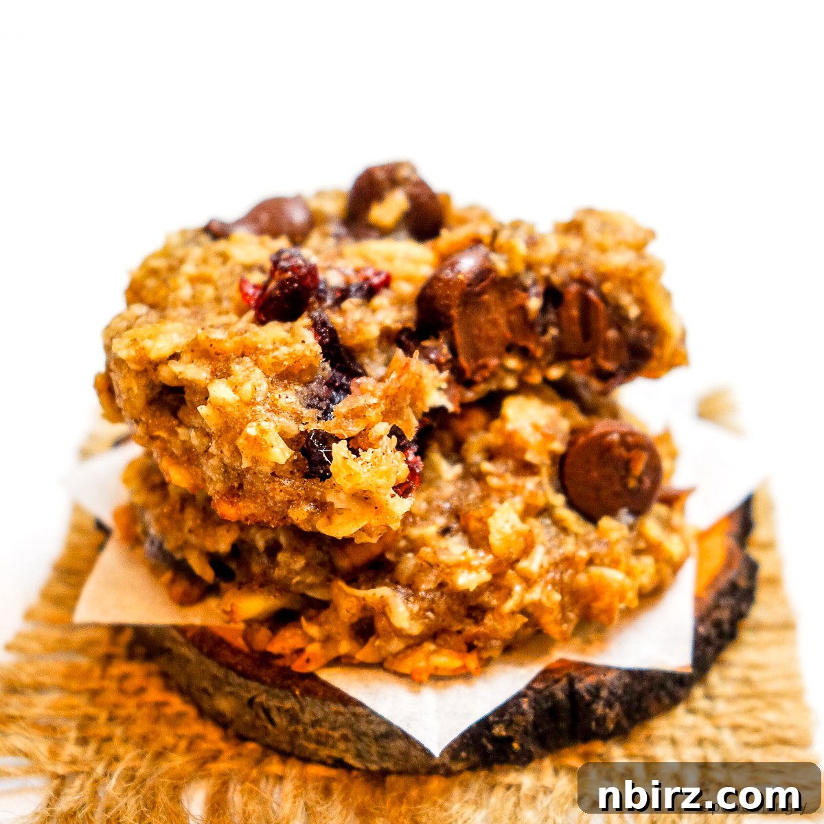 Wholesome Two-Ingredient Banana Oat Cookies 10 Two banana oat cookies, one with a bite taken out, revealing the soft, chewy interior.