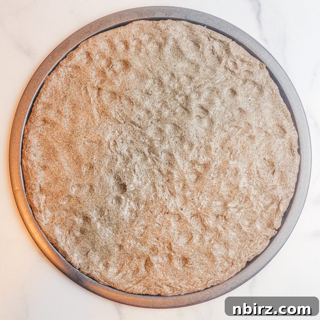 Two-for-Tea Buckwheat Pizza: Simplicity on a Slice 6 Buckwheat pizza dough being pressed out onto a baking pan, ready for pre-baking.