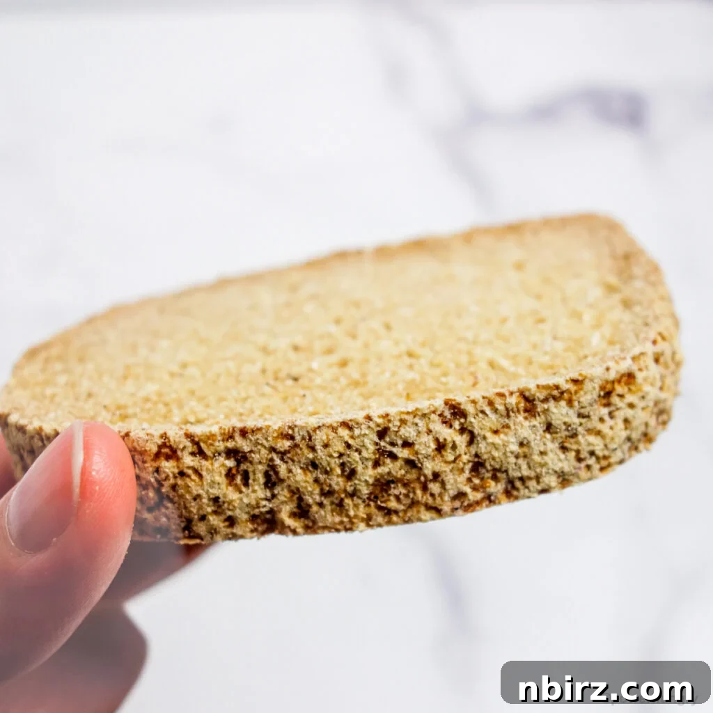 A hand gracefully holding a slice of the wholesome vegan coconut flour bread.