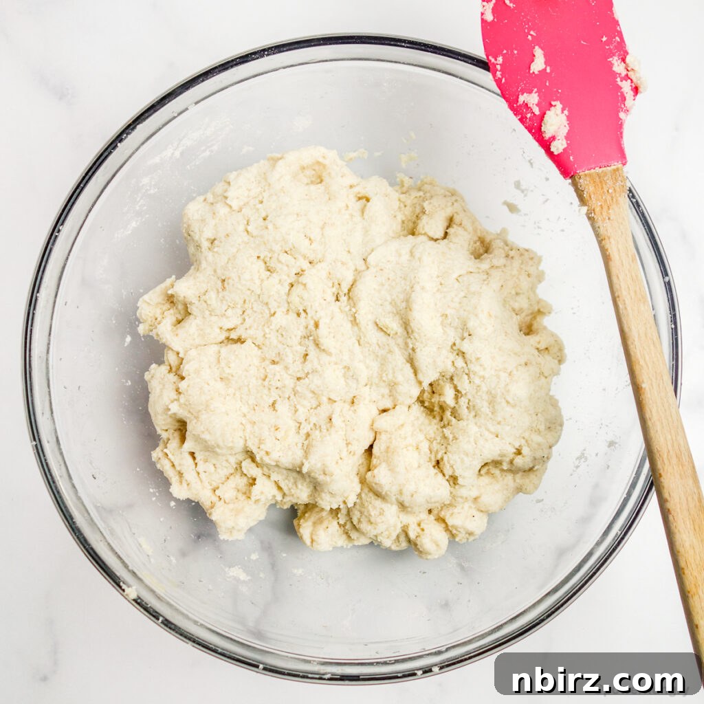 The coconut flour sandwich bread dough in a glass mixing bowl, perfectly combined.