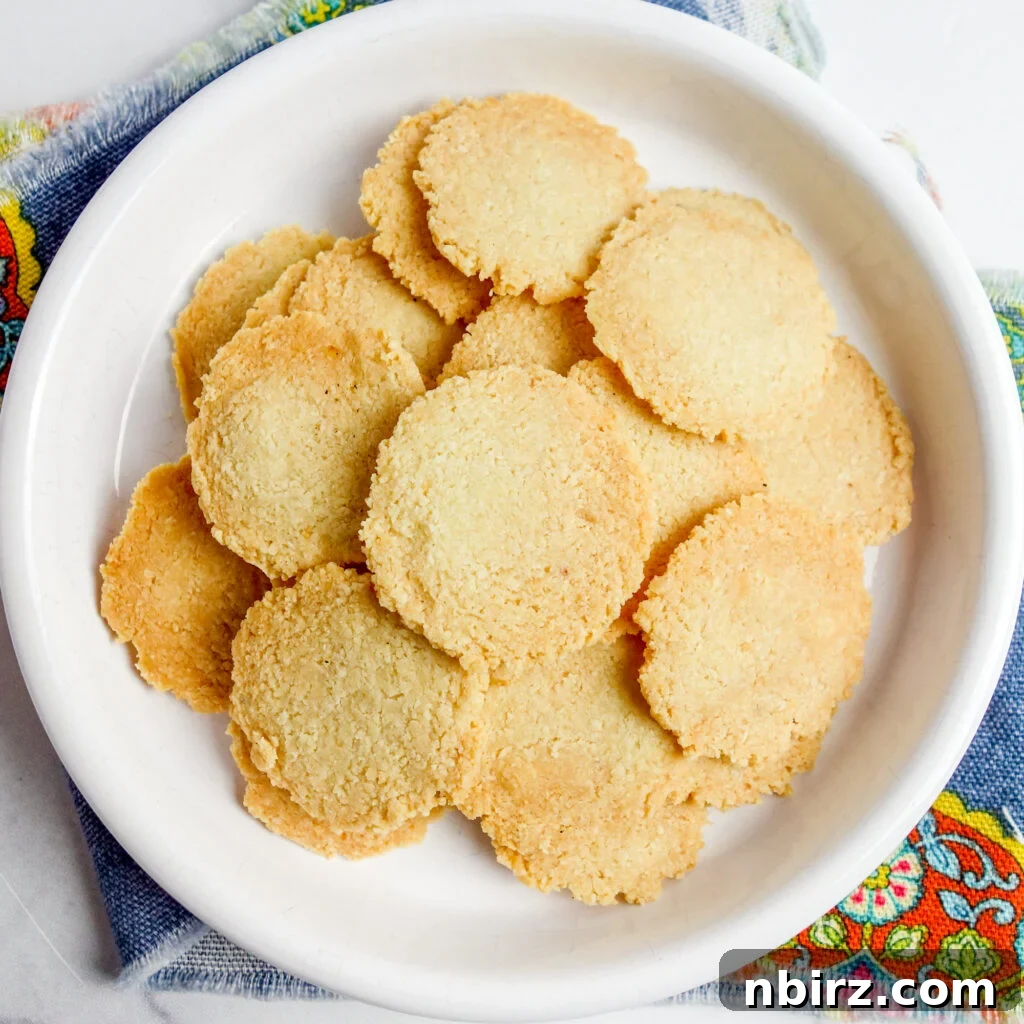 An overhead shot showcasing a pristine white plate abundantly filled with perfectly baked almond flour crackers, inviting viewers to indulge.