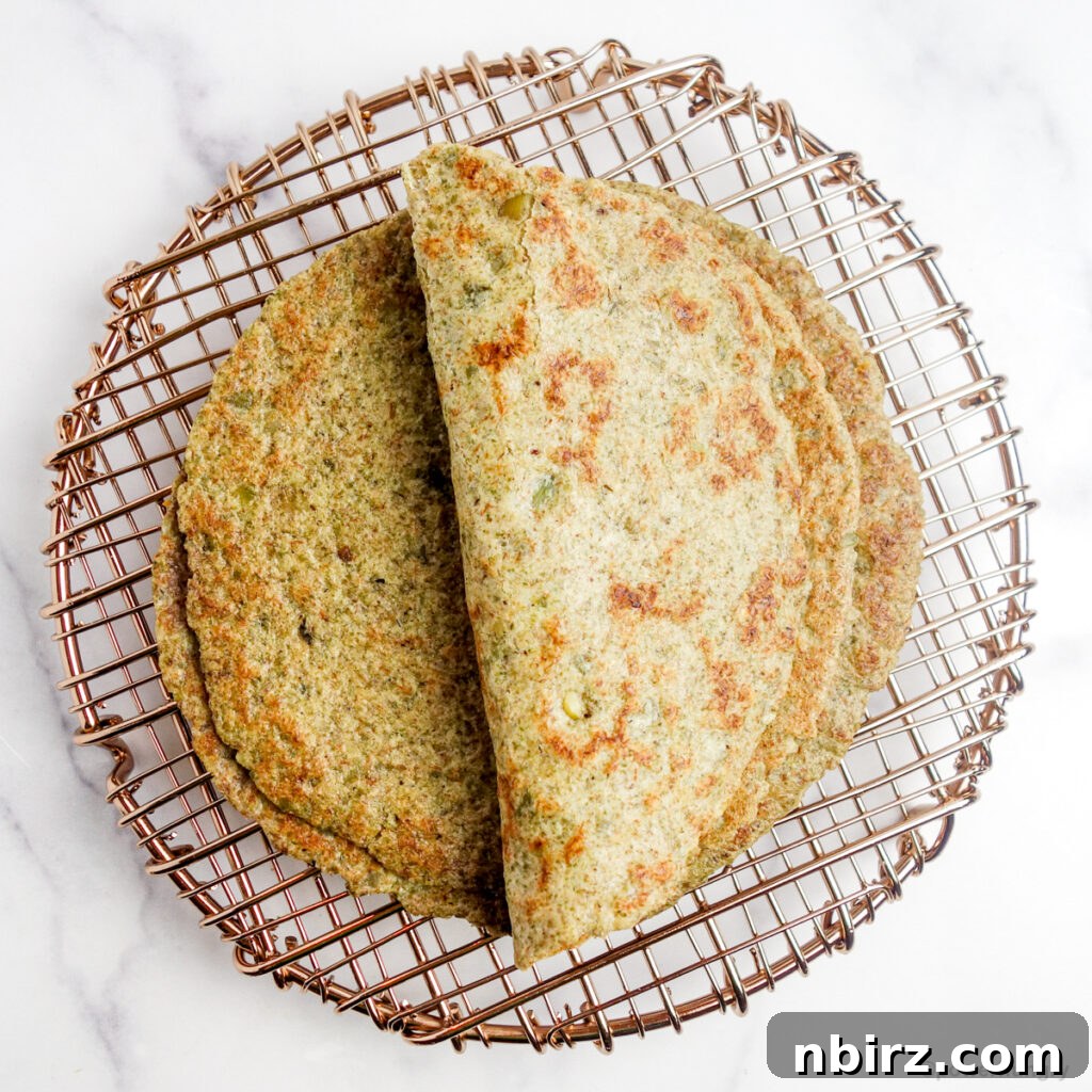 Two-Ingredient Protein-Packed Pumpkin Seed Tortillas 11 A perfectly folded pumpkin seed tortilla resting atop a copper cooling rack, demonstrating its pliable nature.