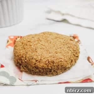 A piece of microwave flax bread, beautifully presented on white parchment paper atop a floral napkin, highlighting its wholesome and appealing nature.