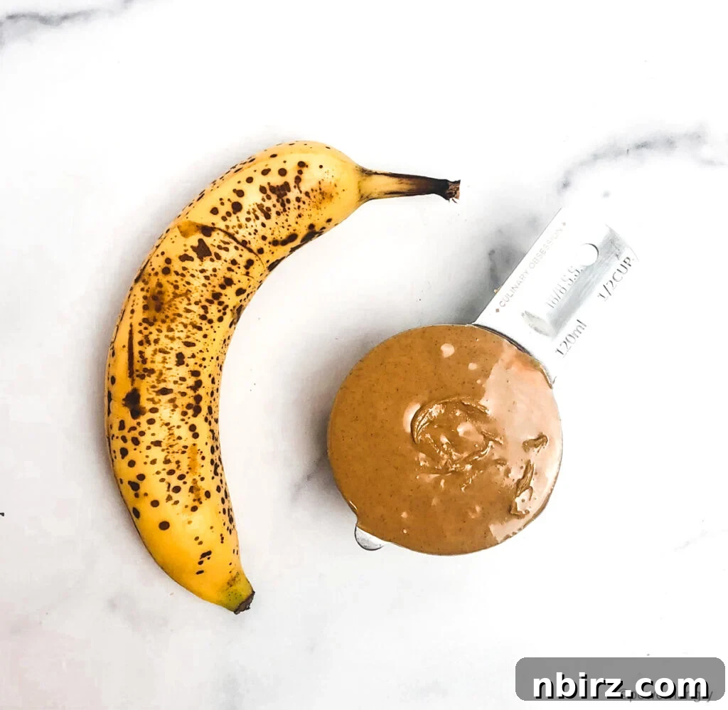 Effortless Two-Ingredient Vegan Gluten-Free Oil-Free Peanut Butter Banana Cookies 4 a ripe banana and a measuring cup full of natural peanut butter