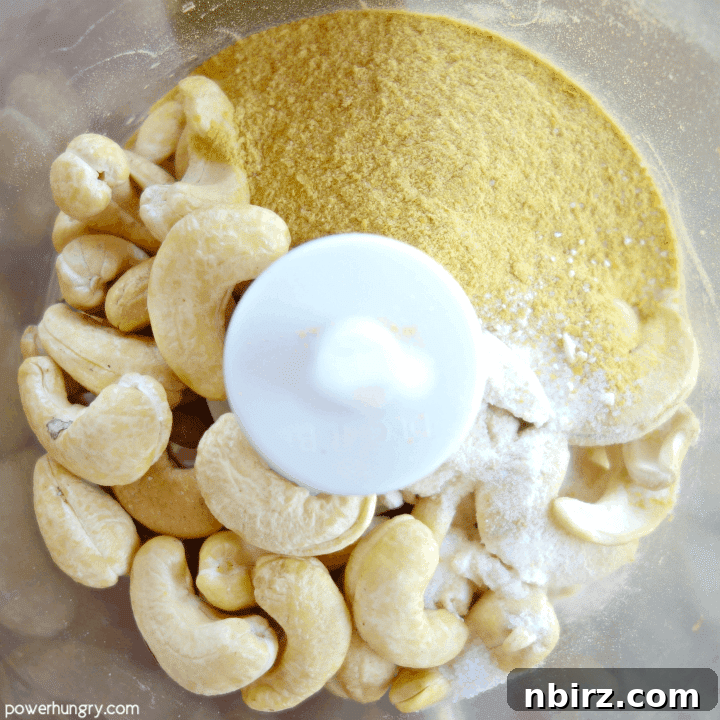 All the raw ingredients for vegan parmesan cheese nestled together in a food processor bowl, ready to be blended into a delicious topping.
