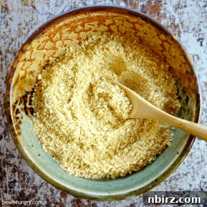 A small, inviting bowl of freshly made homemade vegan parmesan cheese, ready to be used as a delicious topping.