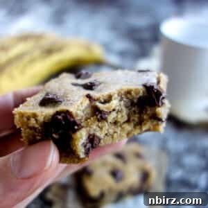An oil-free vegan banana blondie with a bite taken out of it, showcasing its moist texture.