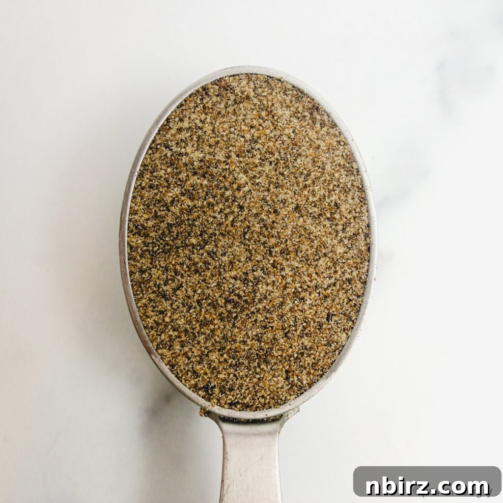 A lightly packed silver measuring cup filled with chia seed flour