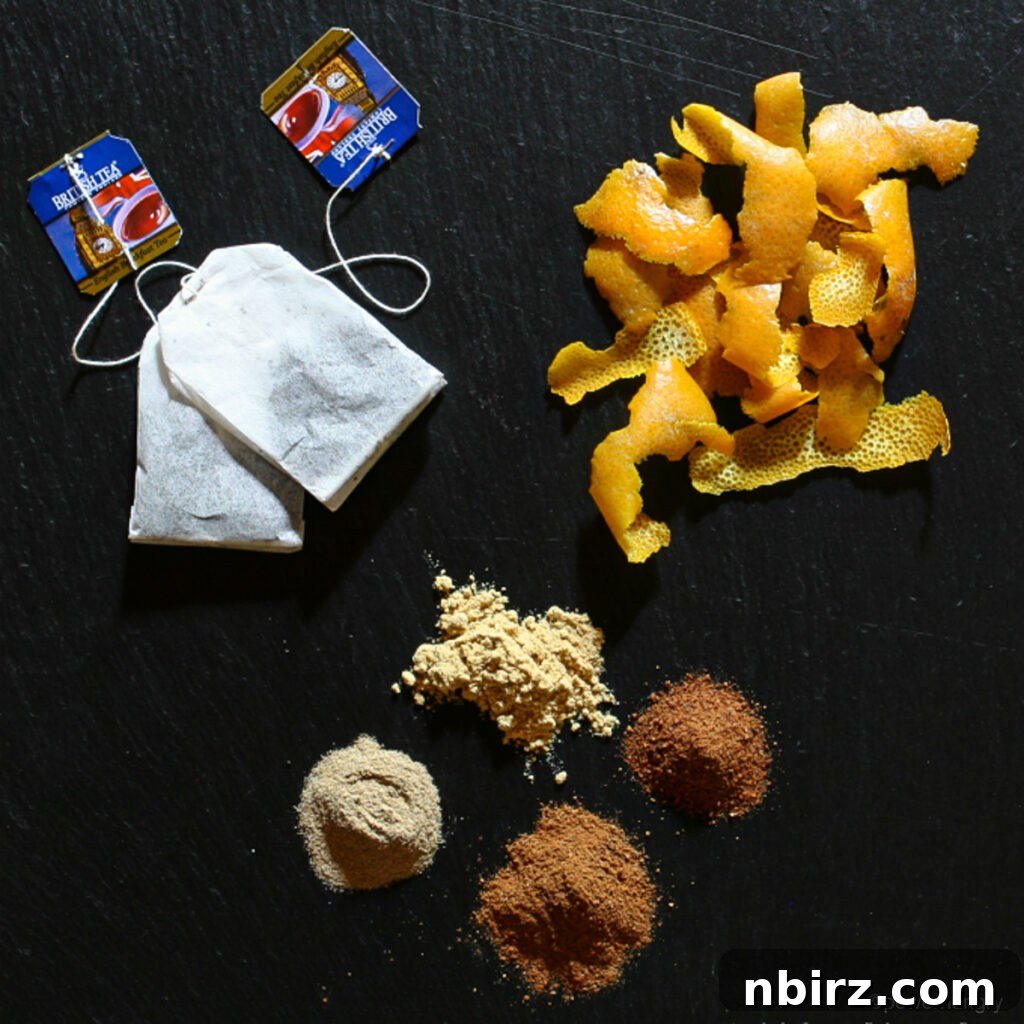 An inviting display of aromatic spices and flavorful orange zest, carefully arranged on a piece of dark slate, showcasing the key ingredients for a perfect Bara Brith.