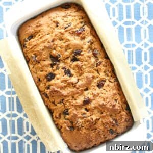 A baked loaf of vegan gluten-free Welsh fruit bread (Bara Brith) in a white dish, ready to be enjoyed.