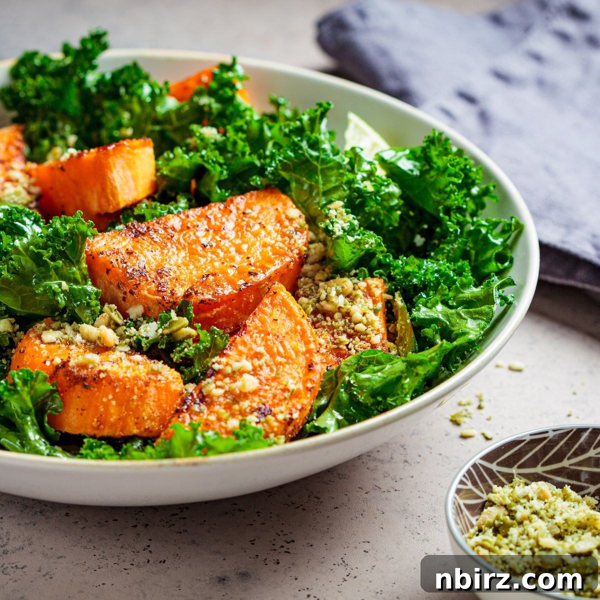 Roasted Sweet Potato & Kale Power Bowl 3 Sweet potato kale salad in a white bowl with a focus on its vibrant texture