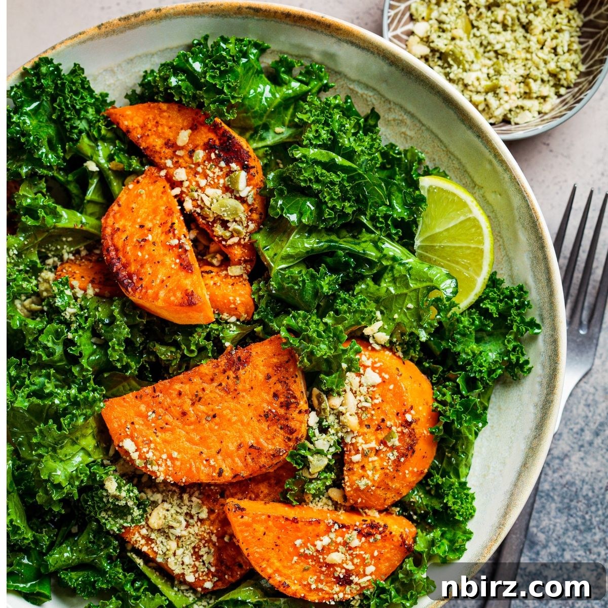 Roasted Sweet Potato & Kale Power Bowl 5 Kale salad in a white bowl with pumpkin seeds, ready to be served