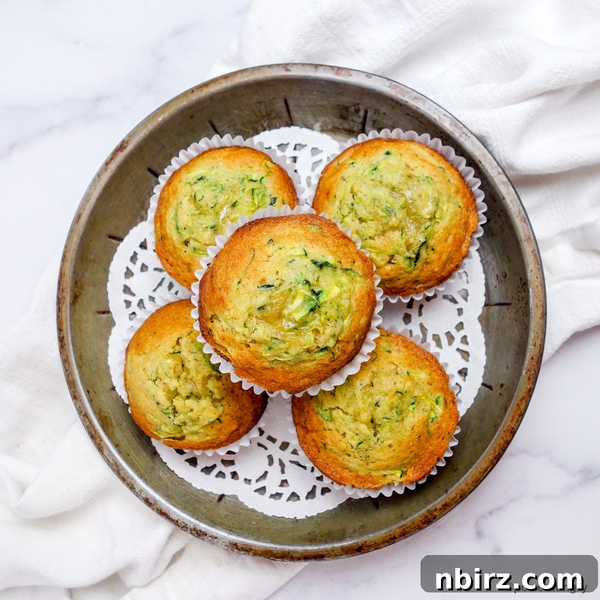An overhead shot showcasing a platter of golden 3-ingredient zucchini muffins, perfect for sharing.