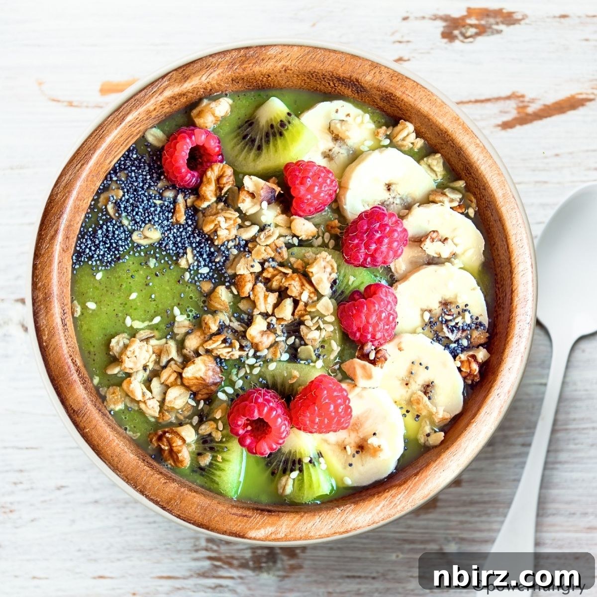 Emerald Morning Bliss 3 Close-up of a green smoothie bowl with various toppings including berries, seeds, and nuts, ready to be enjoyed.