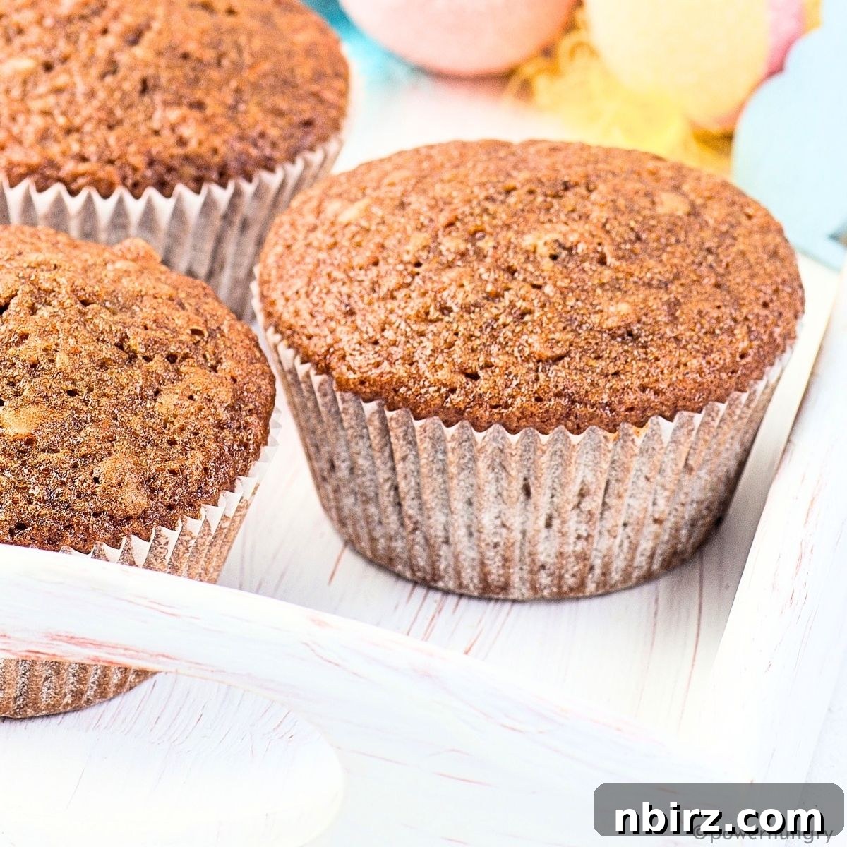 Nourishing Buckwheat Carrot Muffins 3 Close-up of fluffy buckwheat flour carrot muffins arranged on a rustic white tray.