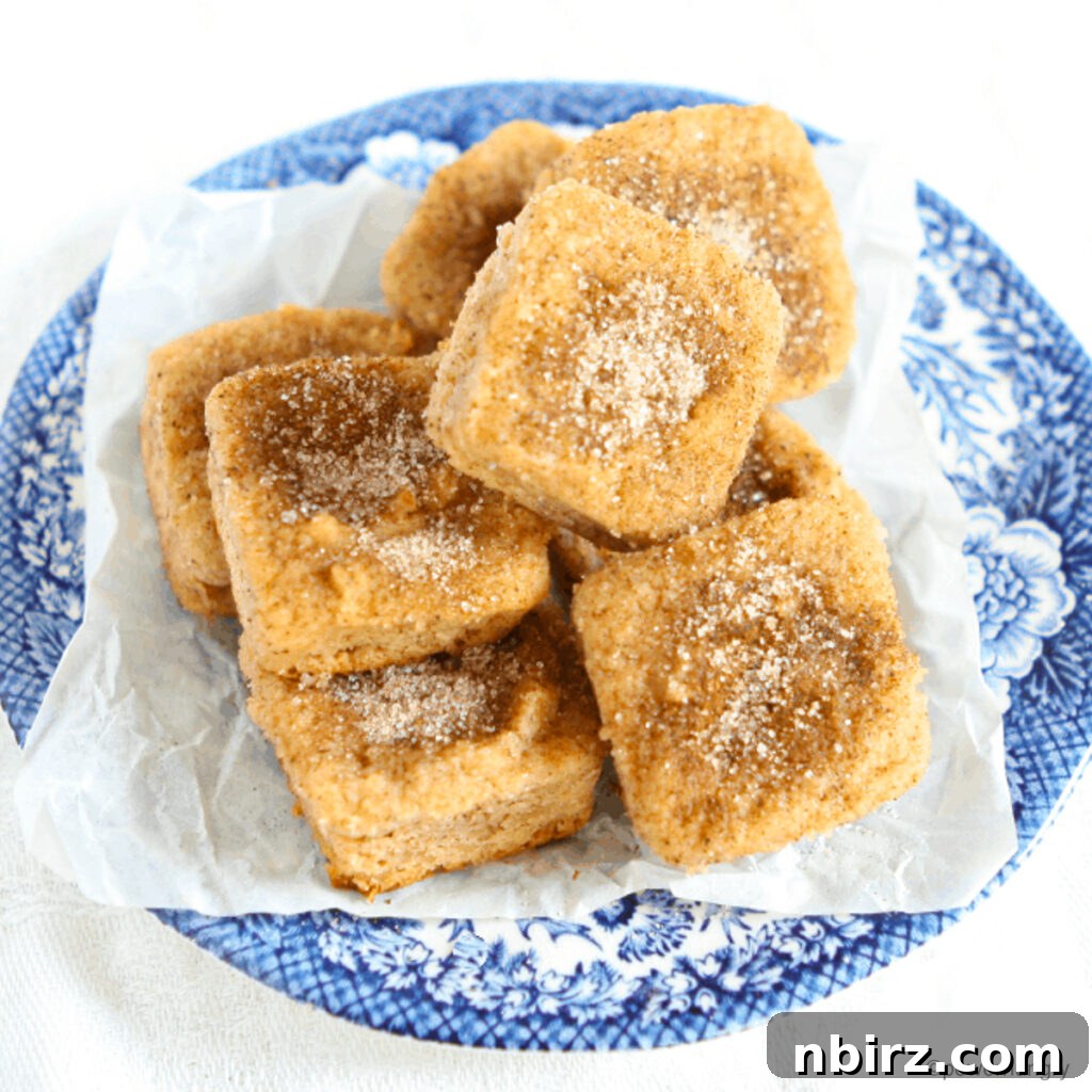 Vegan Coconut Flour Donut Bites Gluten Free 2 A vibrant blue and white dish filled with golden-brown vegan coconut flour donut bites, ready to be enjoyed.