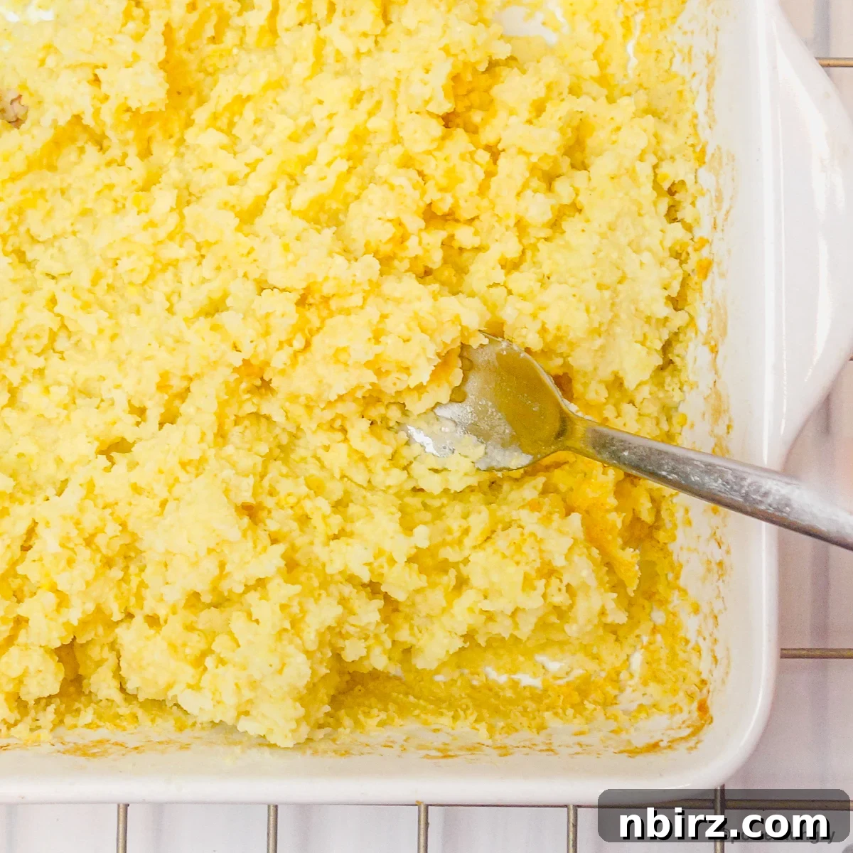 Protein-Packed Millet Nuggets: Just Two Ingredients 6 Close-up of cooked millet being fluffed and mashed with a fork in a baking dish