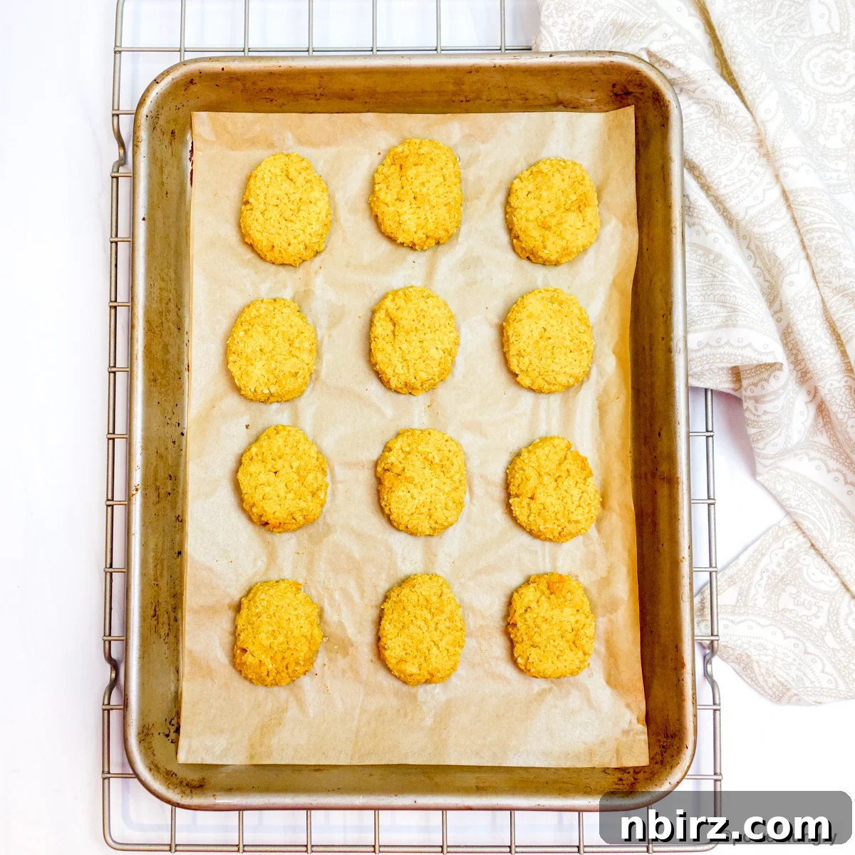 Protein-Packed Millet Nuggets: Just Two Ingredients 8 Vegan millet nuggets baking on a parchment-lined baking sheet in the oven