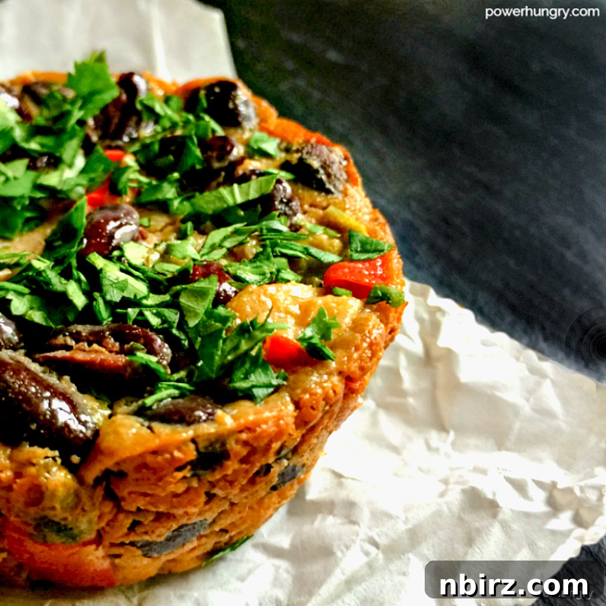 Tex-Mex Black Bean Plant Protein Frittatas 4 Close-up view of a single baked Tex-Mex black bean frittata, highlighting the vibrant colors and hearty texture of the plant-based ingredients.