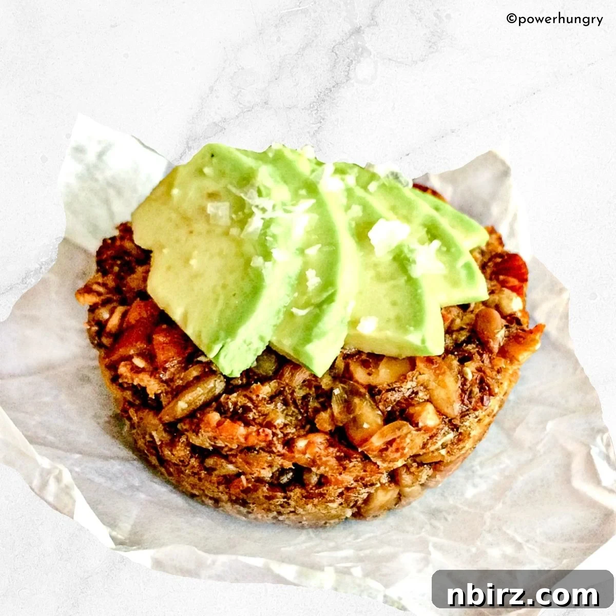 seeded oat protein bread with sliced avocado on top