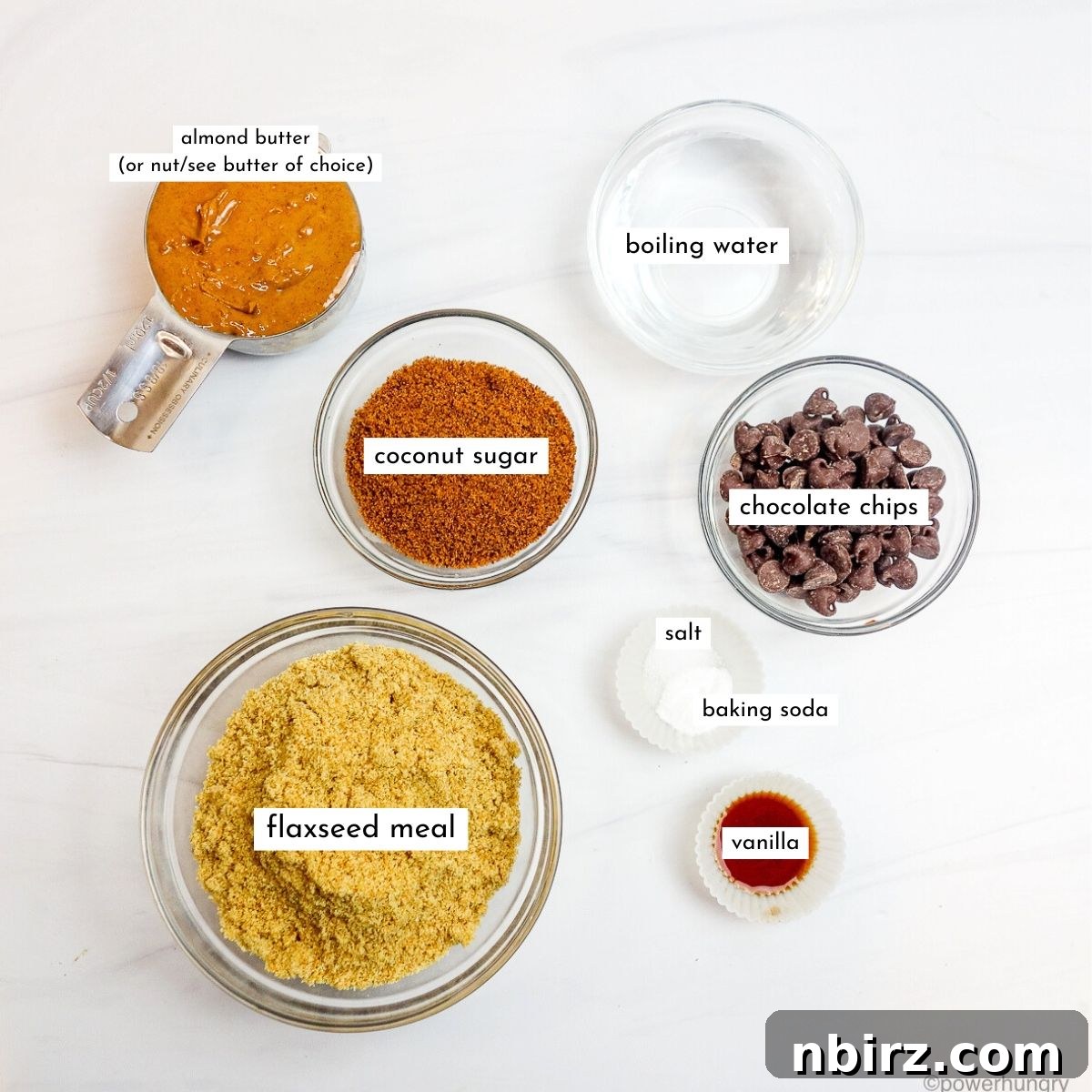 Individual glass bowls display the key ingredients for chocolate chip flax cookies, including ground flaxseed meal, almond butter, and chocolate chips.
