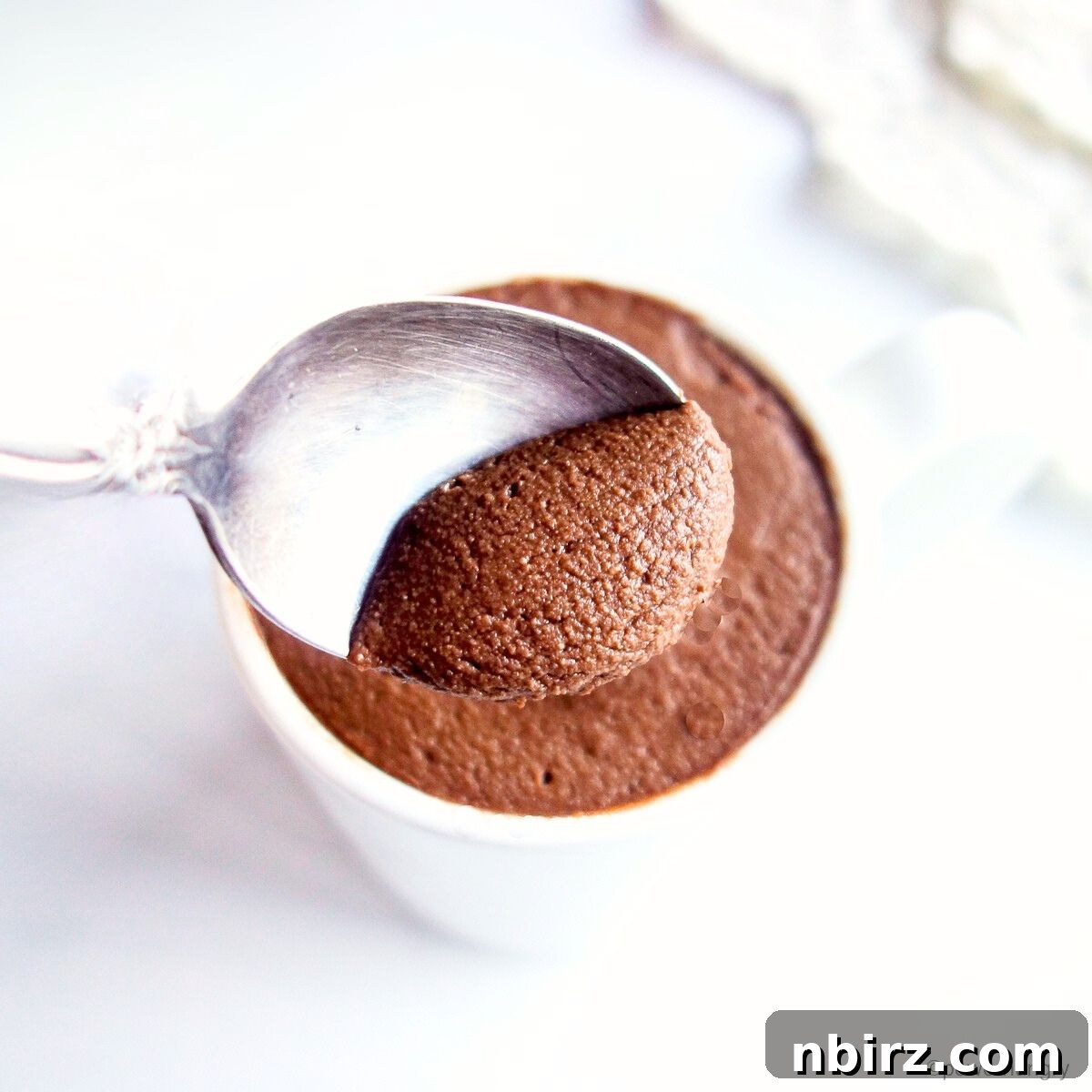 Close-up of smooth, dark vegan protein mousse, emphasizing its rich texture.