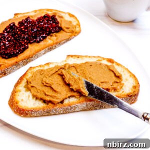 Two pieces of bread on a white plate, topped with roasted chickpea butter