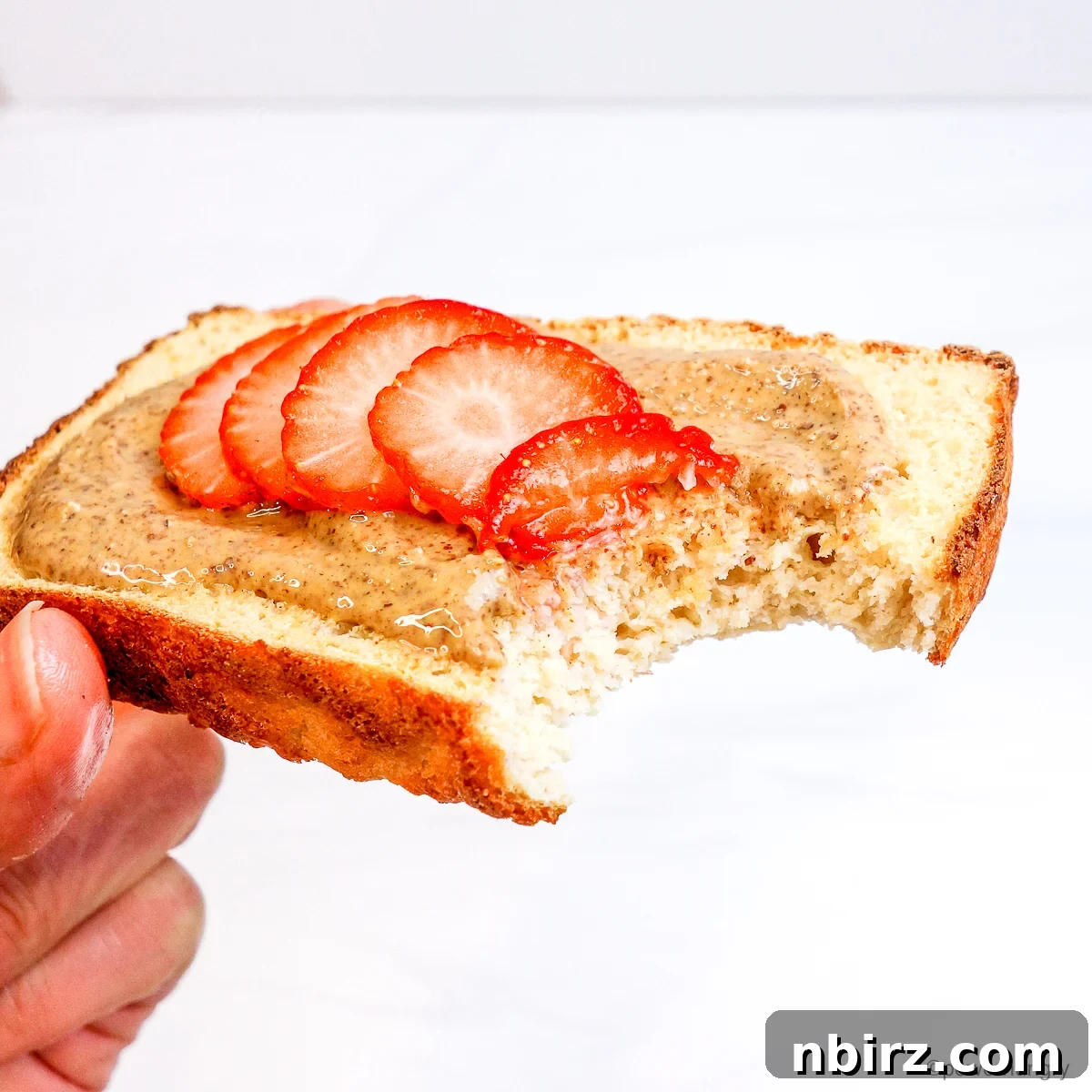 Protein-Packed Bean and Millet Bread Oil-Free Vegan Gluten-Free 4 slice of millet white ben bread topped with almond butter and strawberries