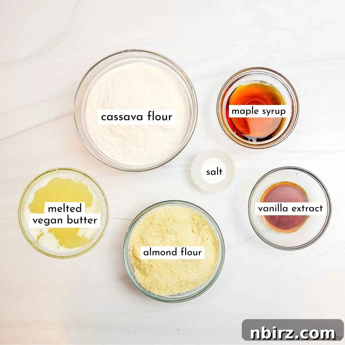 Heavenly Vegan Grain Free Cassava Shortbread Cookies 4 An inviting overhead shot of all the carefully measured ingredients for cassava flour shortbread cookies, neatly arranged in glass bowls on a elegant marble countertop.