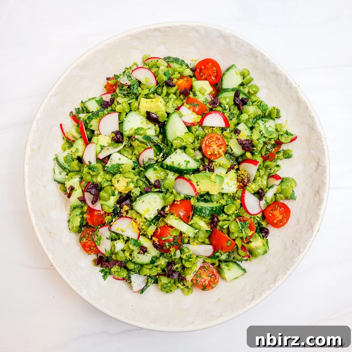 Protein Rich Oil Free Split Pea Salad 8 A freshly made split pea salad, vibrant and inviting, presented in a clean white bowl, ready to be enjoyed.