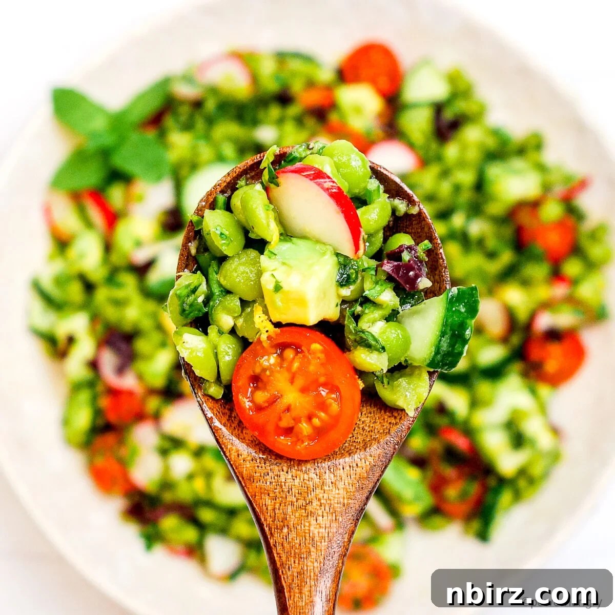 Protein Rich Oil Free Split Pea Salad 9 A generous serving of split pea salad with a wooden spoon, highlighting its fresh ingredients and readiness to be savored.