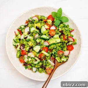 split pea salad in a white bowl with a wooden spoon