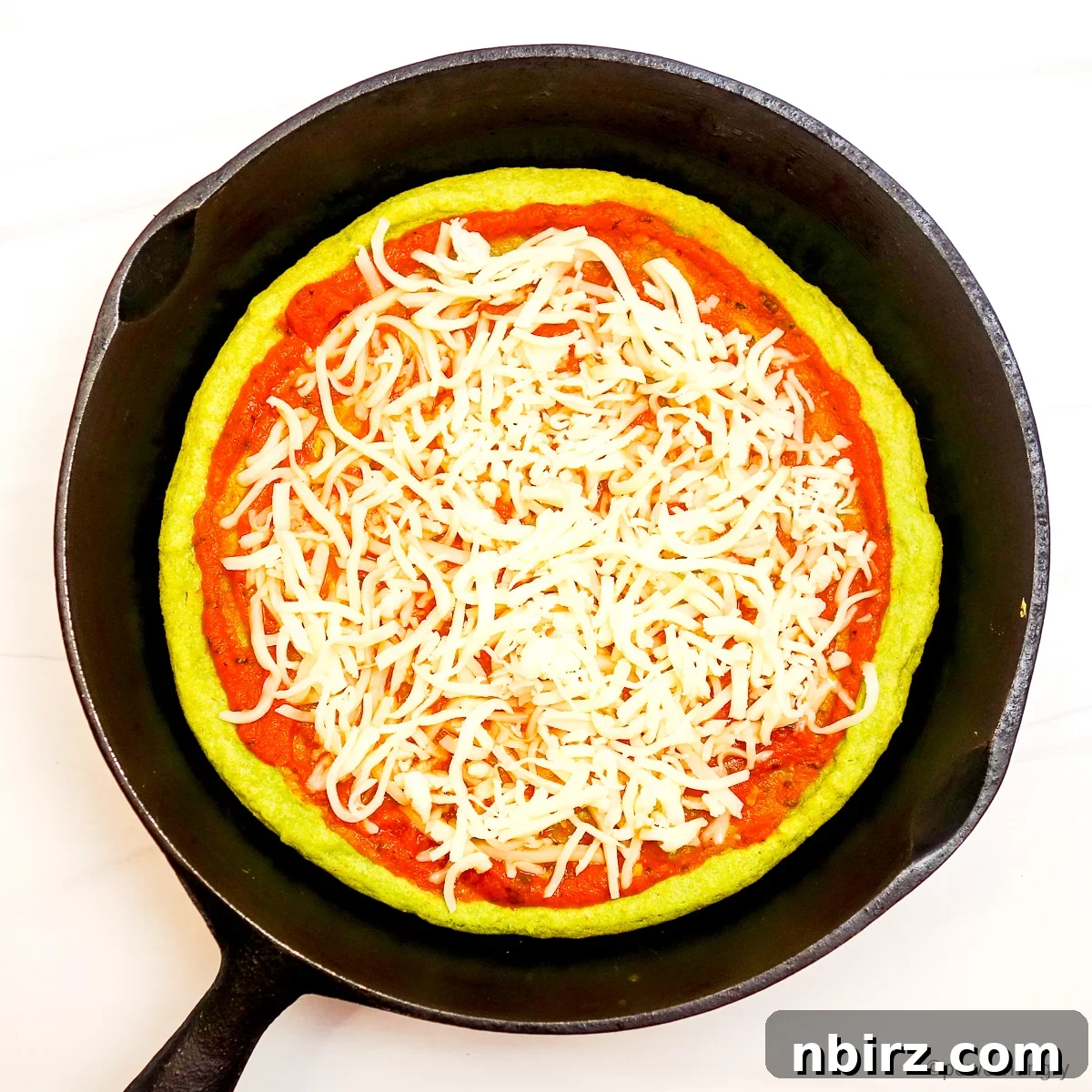 Quick Protein Packed Split Pea Pizza Crust 8 Split pea pizza crust in a skillet, beautifully topped with red sauce and mozzarella cheese, ready for the final bake