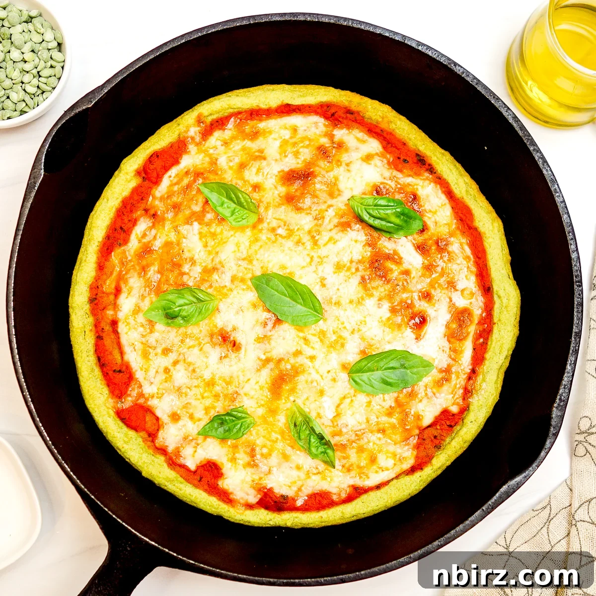Quick Protein Packed Split Pea Pizza Crust 9 A freshly baked, three-ingredient split pea pizza crust in a cast iron skillet, golden and bubbly with toppings
