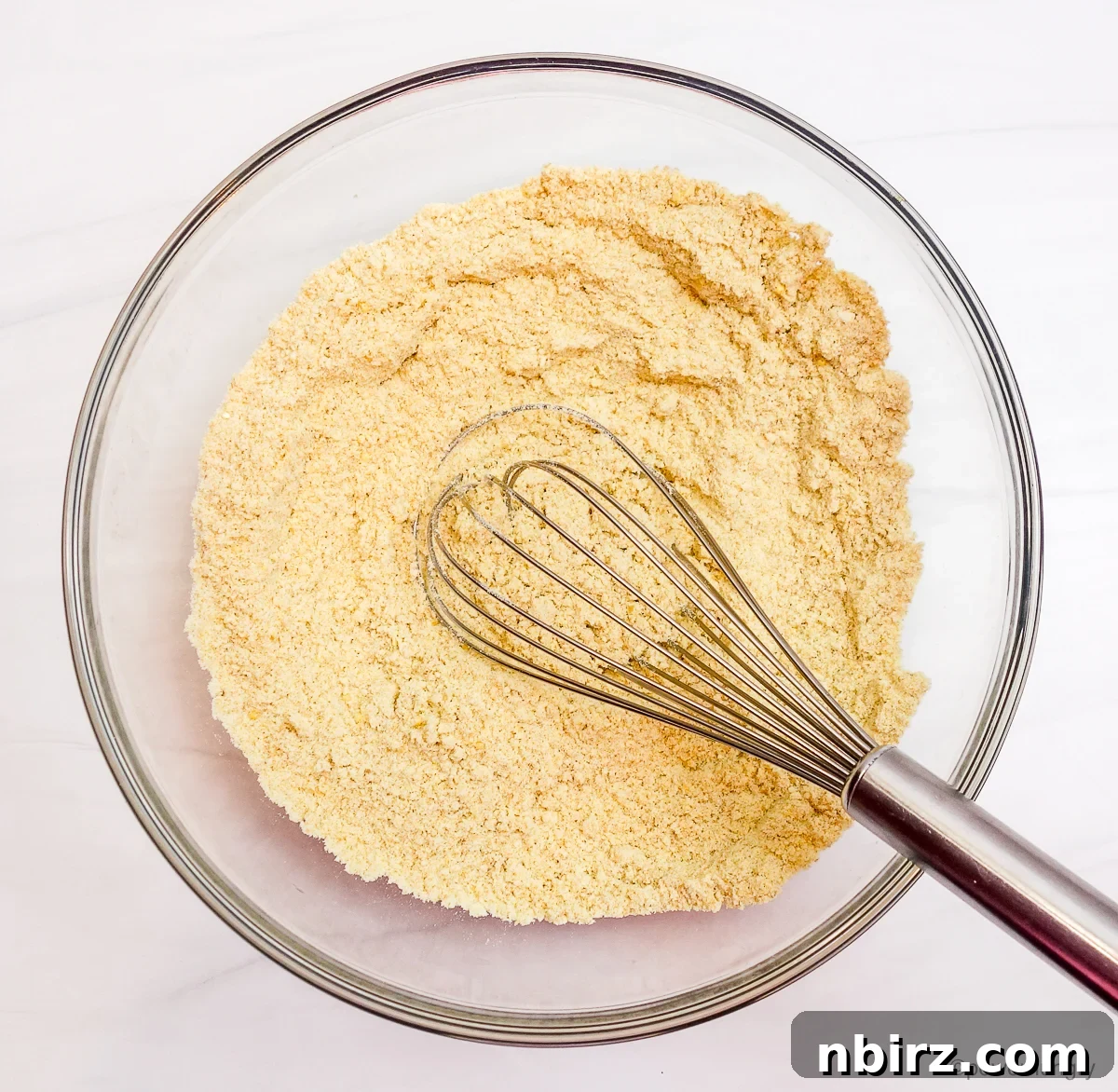 Effortless 4-Ingredient Millet Biscuits: Gluten-Free & Vegan Delight 5 A clear glass bowl containing the dry ingredients for millet biscuits, perfectly prepped for mixing.
