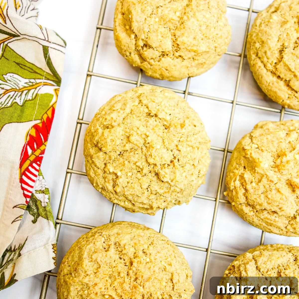 Effortless 4-Ingredient Millet Biscuits: Gluten-Free & Vegan Delight 8 Freshly baked millet biscuits cooling on a gold wire rack, ready to be enjoyed.
