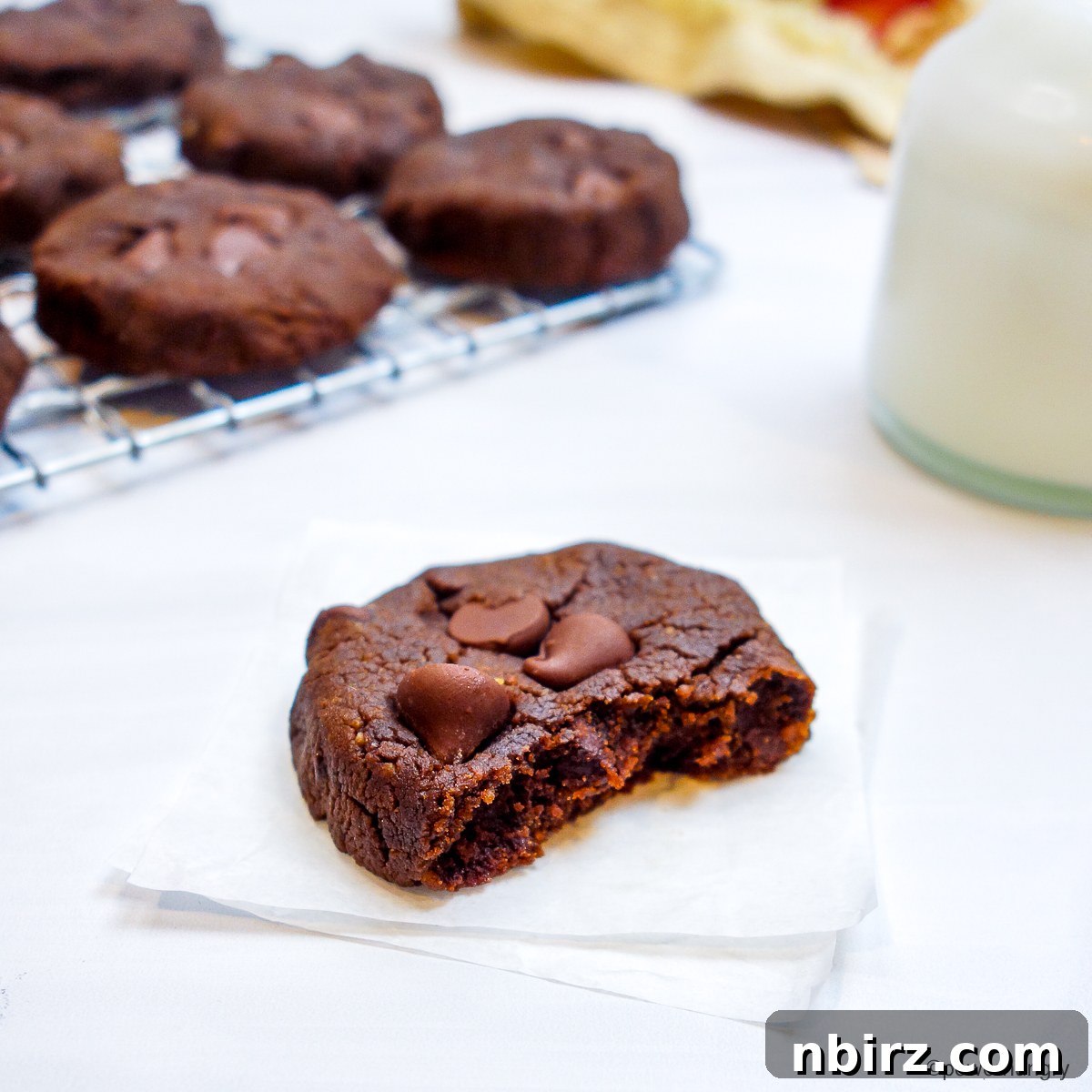 Decadent Vegan Gluten Free Chocolate Peanut Butter Chickpea Cookies 10 A single chocolate peanut butter chickpea flour cookie with a bite taken out, showing its tender interior